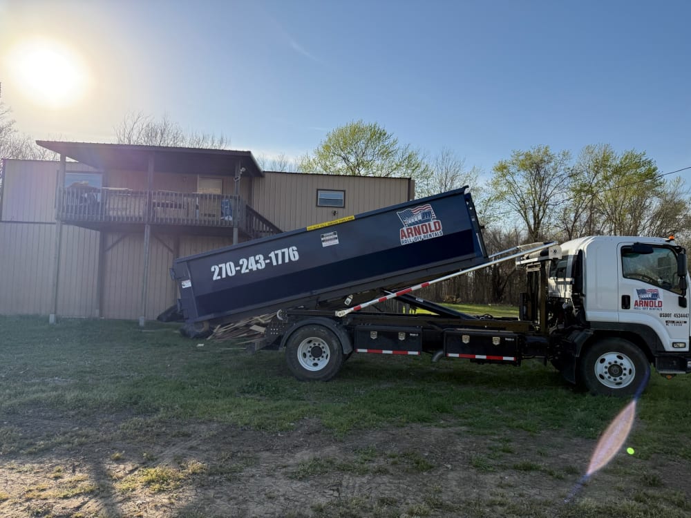 Roll off truck dropping off a dumpster